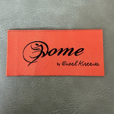 Jacquard woven label LBL 0062 6 x 3 cm – orange base with black letters, soft premium design, with logo